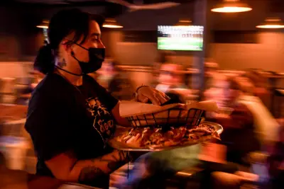 Gov. Jared Polis signs much-amended restaurant tipped wages bill, adding: Your move, Denver.