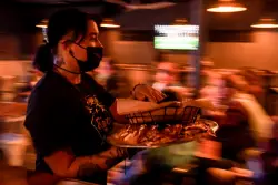 Gov. Jared Polis signs much-amended restaurant tipped wages bill, adding: Your move, Denver.